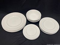 Full set overview showing 4 dinner plates, 4 luncheon plates, 4 bread and butter/dessert plates, and 4 cereal bowls arranged on black cloth.
