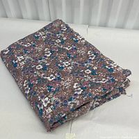 Folded cotton fabric with floral print showing the overall look and size.