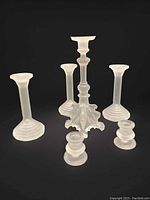 Full view of all six frosted glass candlesticks showing the griffon themed centerpiece and five additional holders.