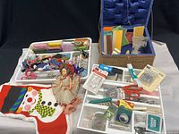Wide view showing sewing supplies, embroidery thread, bias tape, scissors, pins, beads, and vintage doll.
