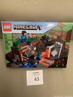 Front of the Lego Minecraft box showing the full setup of The Abandoned Mines set including figures and terrain.