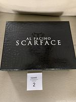 Black textured collector box labeled 'Al Pacino Scarface' containing the boxset.