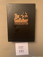 Black box with gold 'The Godfather DVD Collection' title and puppet logo on front.