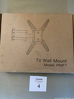 Closed cardboard box with printed image of TV wall mount and labeled 'TV Wall Mount Model: PIMF7'