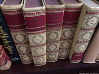 Six hardcover volumes from The Complete Books of Mark Twain collection on shelf showing spine details with red and cream labels, gold decoration, volume numbers 11 to 16 with some wear on bindings.