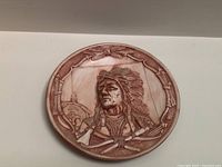 Carved wooden plaque with Native American portrait in traditional headdress, round shape with decorative border