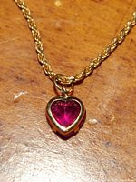 Close-up front view of heart-shaped ruby pendant and bail.