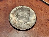 Obverse side of 1964 John F. Kennedy Silver Half Dollar showing Kennedy's profile and inscriptions with visible wear and patina.