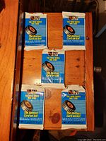 Five unopened NHL Pro Set 1990 Series One hockey card packets arranged on wood surface.