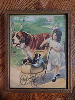 Frontal photo of giltwood framed vintage print depicting a girl with a doll stroller, two puppies, and a large Saint Bernard dog, set outdoors with trees and a house in the background.