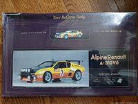 Box front showing the Alpine Renault A-310V6 rally car illustration with yellow paint, rally number 2, and decals. Box is in original shrink wrap with damaged corner.