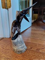 View of handcrafted bull horn fish sculpture highlighting detailed scales, face, and carved fins mounted on bull horn base.