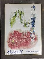 Framed Marc Chagall exhibition poster showing colorful figure and landscape in an 18x25 frame with minor staining on bottom corners.