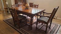 Full view of table with leaves extended and six chairs around on area rug