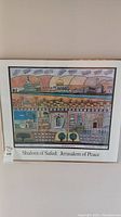 Framed artwork showing stylized Jerusalem cityscape titled 'Shalom of Safed: Jerusalem of Peace'