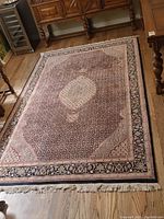 Full view of rug on hardwood floor showing overall pattern and medallion center