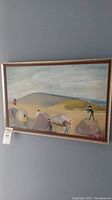 Framed painting overview showing composition of figures on rocks and shoreline