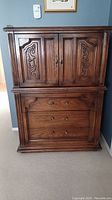 Full view of the dresser showing both drawers and upper cabinets with wood grain and knobs visible.