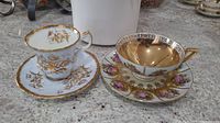 Both cup and saucer sets side by side on countertop