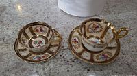 Two teacups and two saucers displayed on countertop