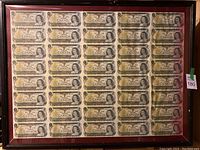 Full view of the framed uncut sheet of Canadian one dollar bills showing all 40 bills.