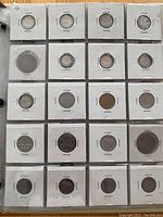Six pages of Canadian and world coins mounted in cardboard holders inside plastic sleeves, showing a variety of coins in different sizes and metals.