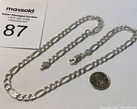 Sterling silver chain necklace laid out flat beside a Canadian dime for size scale.