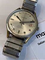Close-up front view of the vintage Waltham watch face showing the day and date windows, dial markers, and hands.