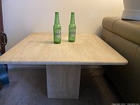 Frontal view of square marble top with two bottles for scale