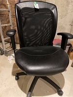 Front view of the black office chair showing mesh back, padded faux leather seat, and armrests.