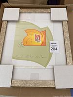Framed limited edition postal stamp with protective corner padding inside box