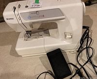 Full side view of off-white Kenmara sewing machine with attached foot pedal and electrical cord.