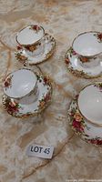 Four Royal Albert bone china cups and matching saucers arranged on a surface with a lot number card visible.