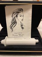 Derma Wand device and Usage Guide pamphlet in black foam case.