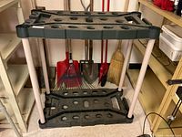 Front view of plastic garden tool rack with tools behind it