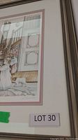 Photo showing framed print with gray frame and white/mauve matting, signed by S. Deauville, with a green sticker and lot label visible.