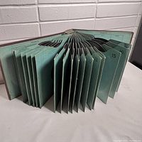 Photo of antique binder album with numbered accordion sleeves visible