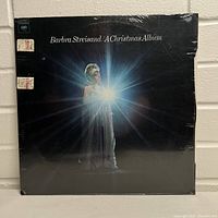 Front cover of Barbra Streisand A Christmas Album showing Barbra Streisand illuminated by bright light, sealed in original shrink wrap.