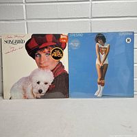 Photo shows two Barbra Streisand sealed vinyl LP albums: 'Songbird' and 'Superman', showing front covers and price stickers.