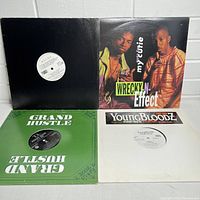 Four 12-inch DJ vinyl records, showing Wreckx-n-Effect cover, Grand Hustle green sleeve, YoungBloodZ white sleeve, and one blank black sleeve.
