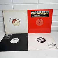 Four 12-inch vinyl records in original and plain sleeves, showing front covers and labels, including Jagged Edge and Charlie's Records.