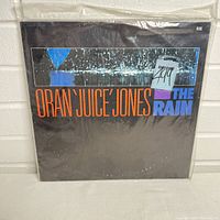 Front cover of the sealed vinyl album Oran 'Juice' Jones The Rain showing artwork and text.