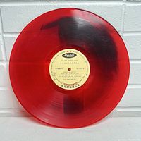 Full view of red translucent vinyl record showing side B and label with Haishan Records branding and song titles.