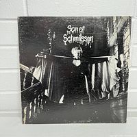 Front of Son of Schmilsson album cover, showing black and white image of Harry Nilsson with album title.