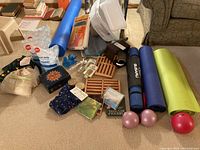 Photo showing full lot contents: yoga mats, unopened Epsom salts, wooden rollers, CDs, balls, and textile accessories.