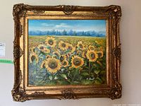 Full view of framed oil painting showing sunflower field and ornate gold-tone frame