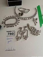 All jewelry pieces including bracelets, earrings, brooch, and necklace piece displayed together on a surface