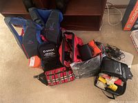 Photo showing two blue and black life preservers and multiple emergency supply bags on floor