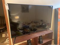 Front view of TV on stand showing overall size, condition and screen.