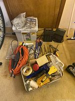 Lot of mixed hand tools, extension cords, space heaters, and boxes showing assortment and condition.